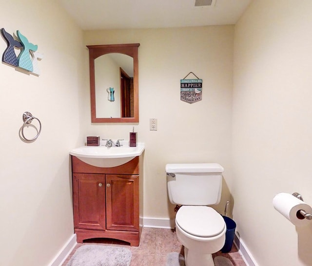 bathroom featuring tile patterned flooring, vanity, and toilet