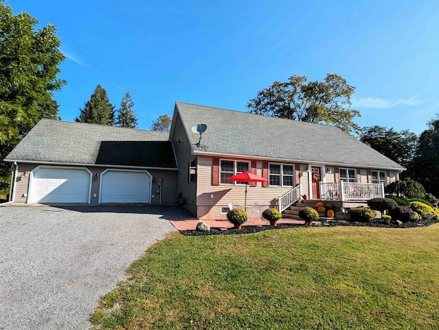 view of front facade with a front yard, a garage, and a wooden deck