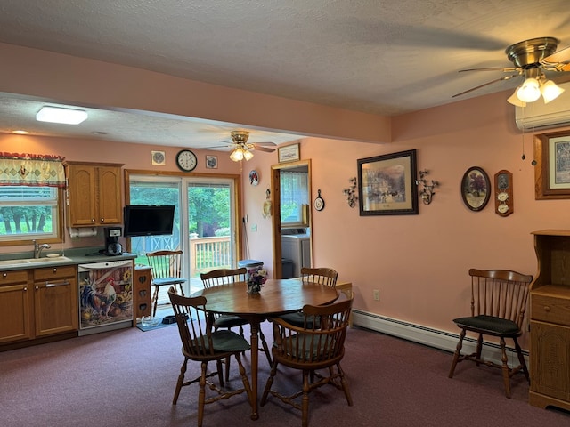 carpeted dining space featuring a textured ceiling, sink, baseboard heating, ceiling fan, and washer / dryer