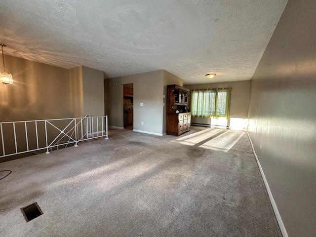 carpeted spare room with a textured ceiling