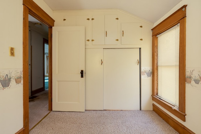 unfurnished bedroom featuring lofted ceiling, light carpet, and multiple windows