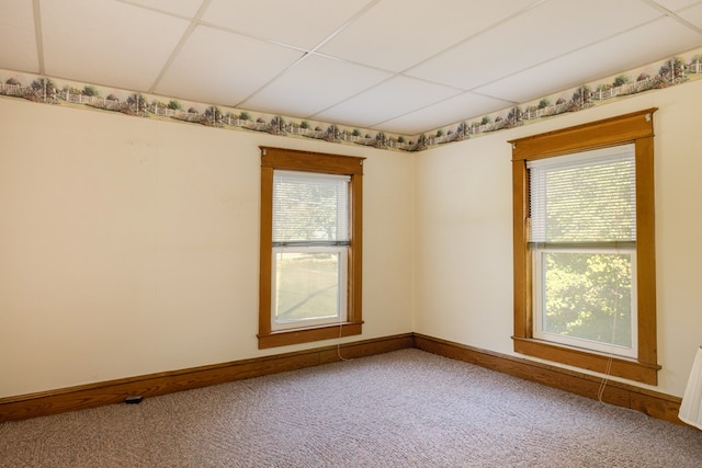 carpeted spare room featuring a paneled ceiling