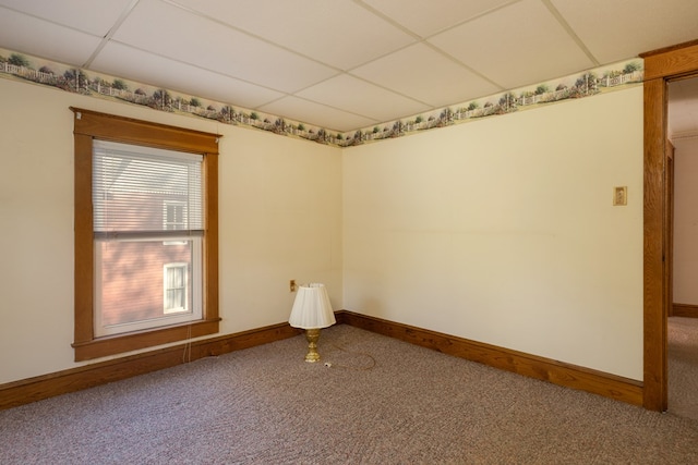 carpeted empty room with a paneled ceiling