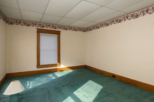 empty room featuring carpet flooring and a paneled ceiling