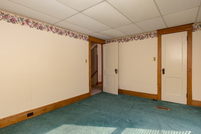 carpeted spare room with a paneled ceiling