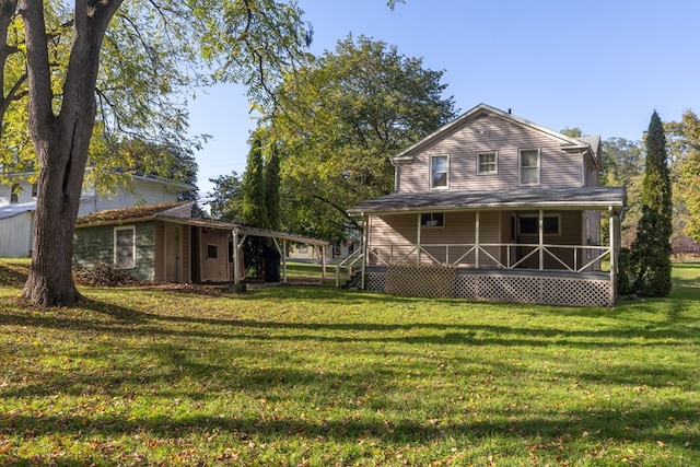 rear view of house featuring a yard, an outbuilding, and a porch