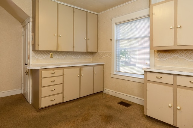 kitchen with tasteful backsplash, light colored carpet, plenty of natural light, and crown molding