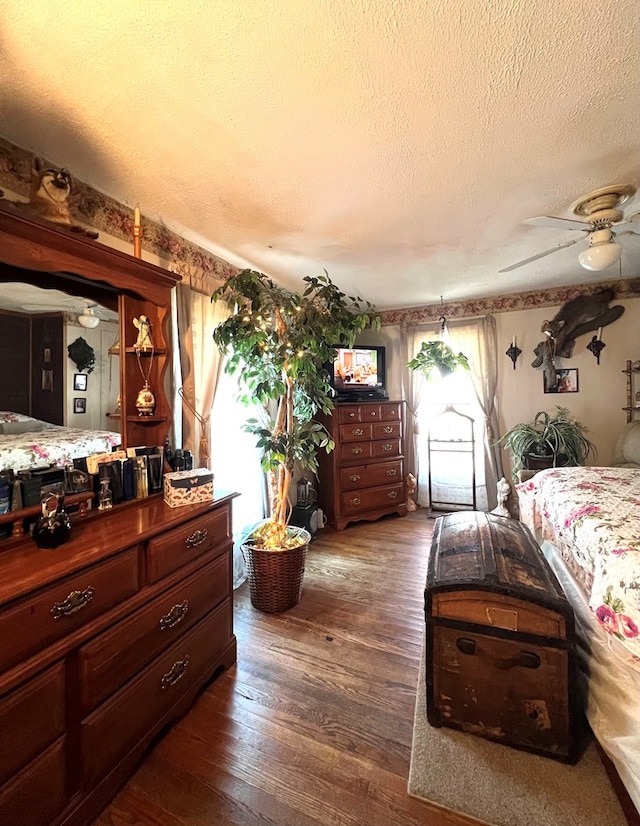 bedroom featuring dark wood-type flooring, a textured ceiling, and ceiling fan