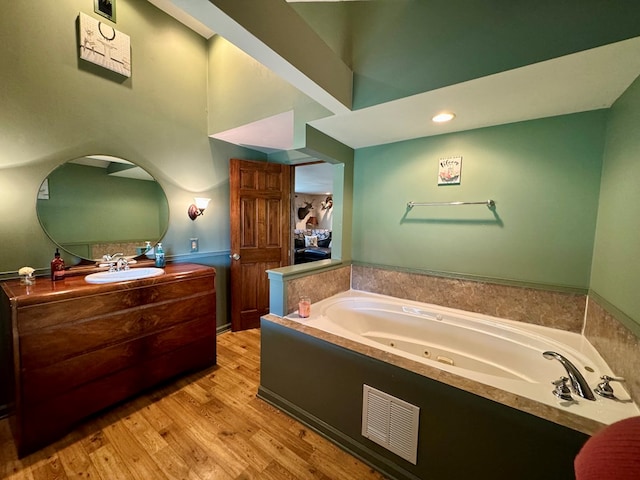 bathroom featuring a tub to relax in, vanity, and hardwood / wood-style flooring