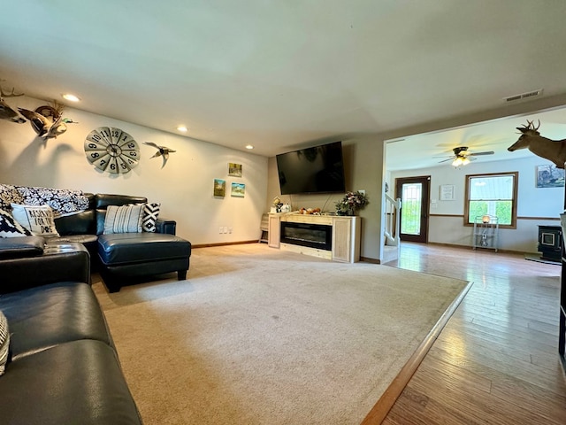 living room featuring ceiling fan and light hardwood / wood-style floors