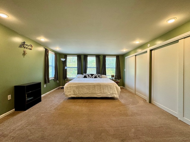 bedroom featuring carpet, a textured ceiling, and two closets