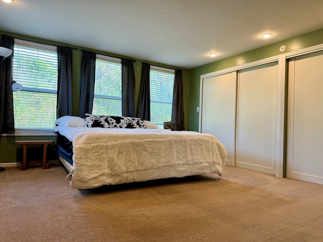 carpeted bedroom with multiple windows