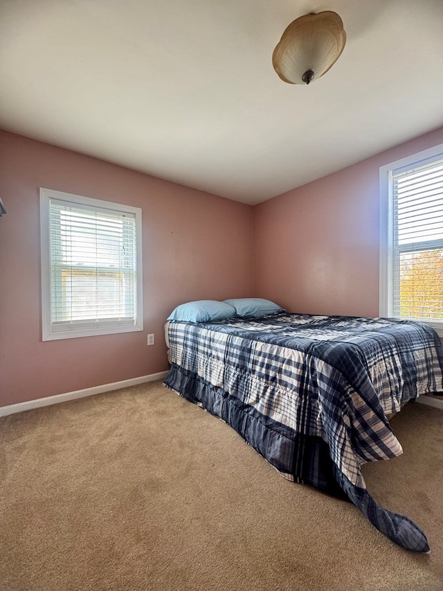 carpeted bedroom featuring multiple windows