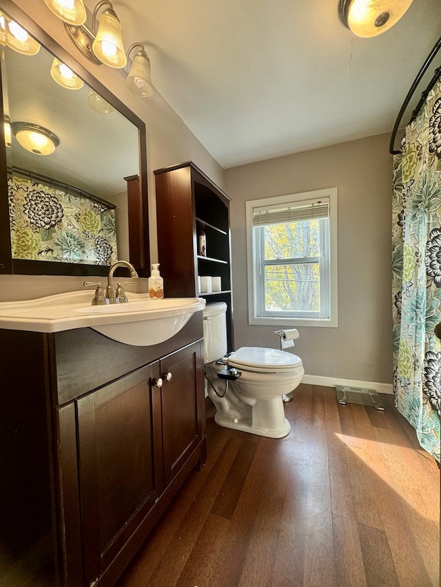 bathroom with hardwood / wood-style flooring, vanity, and toilet