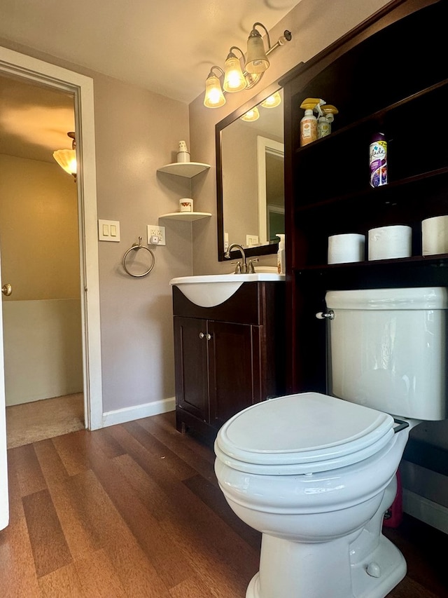 bathroom with hardwood / wood-style flooring, vanity, and toilet