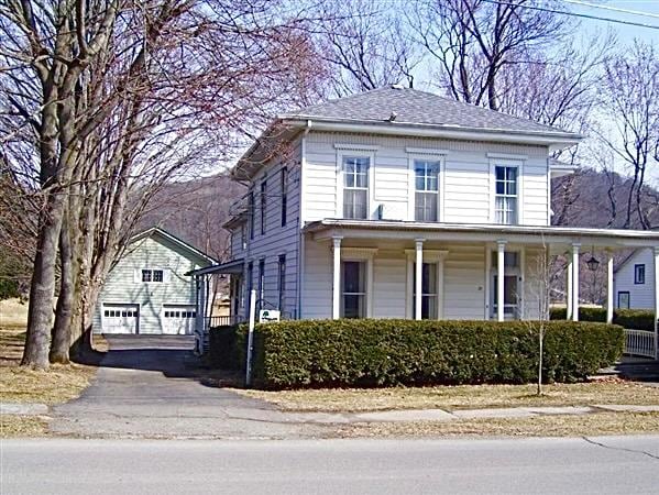 view of front of home with an outbuilding, a garage, and a porch