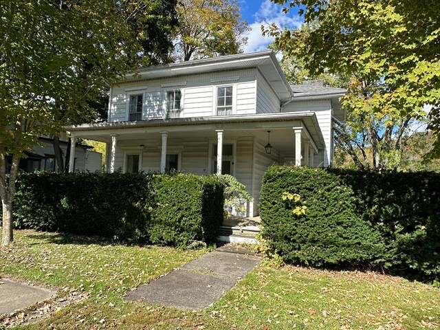 view of front of property featuring covered porch and a front lawn