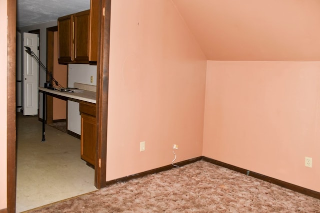 interior space with light carpet and lofted ceiling