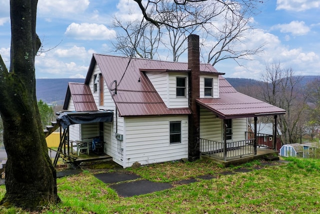 rear view of property featuring an outbuilding and a porch