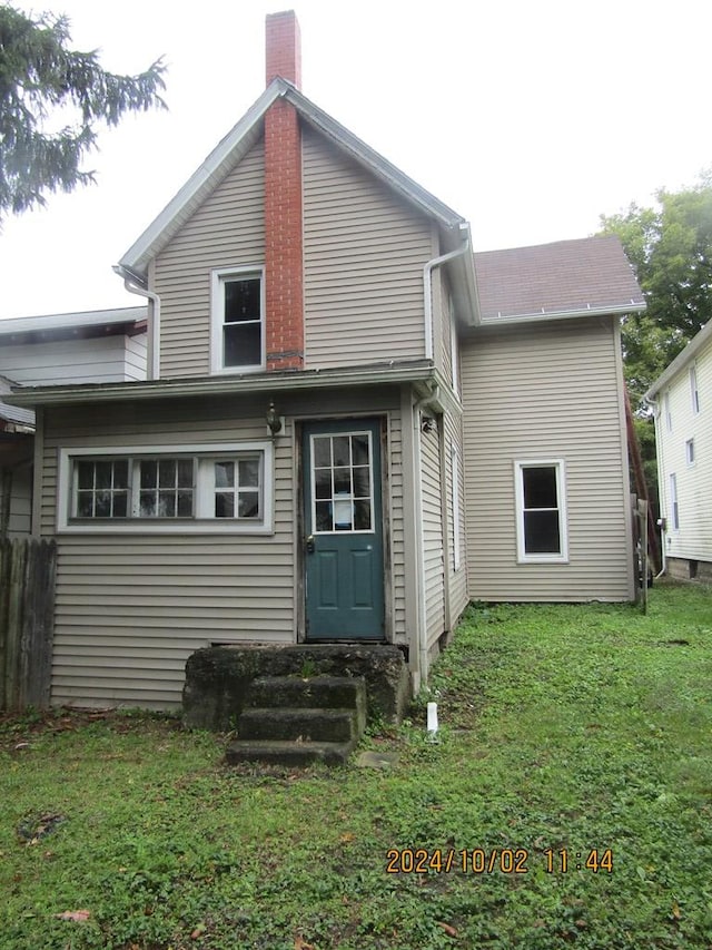 rear view of house featuring a lawn