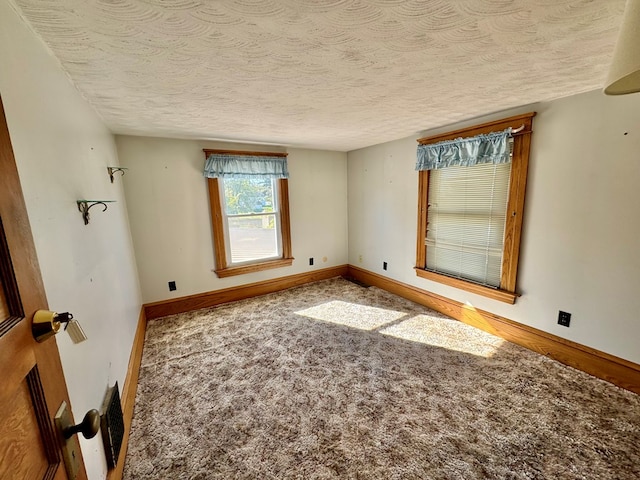 carpeted spare room with a textured ceiling