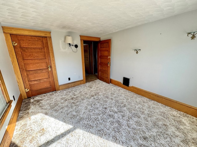 unfurnished bedroom featuring carpet and a textured ceiling