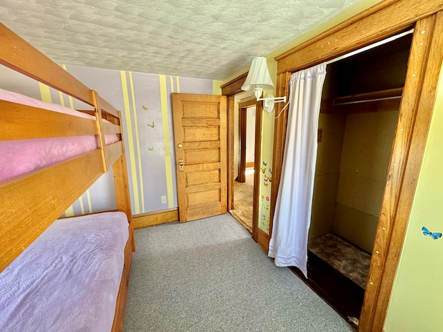 carpeted bedroom with a textured ceiling and a closet