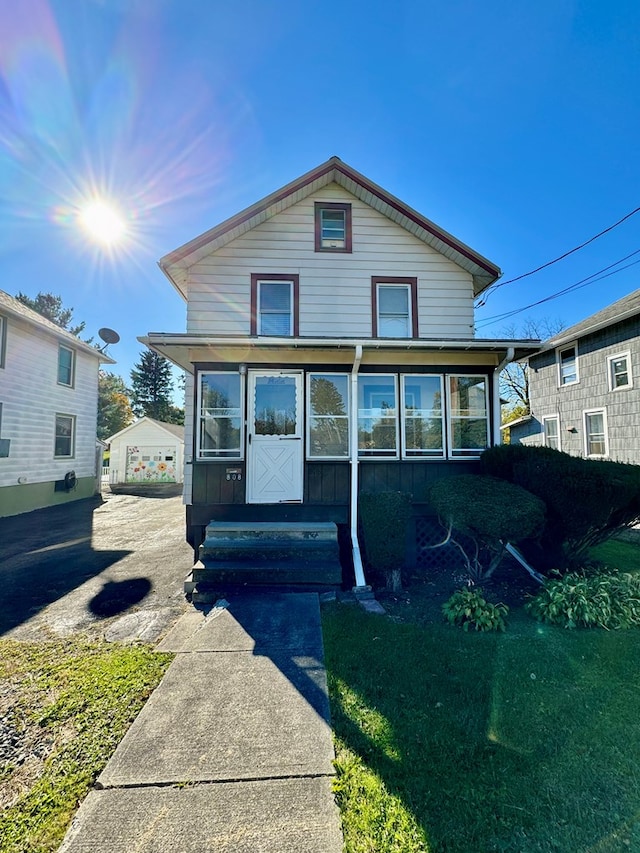 view of front of house with a sunroom, an outbuilding, and a garage