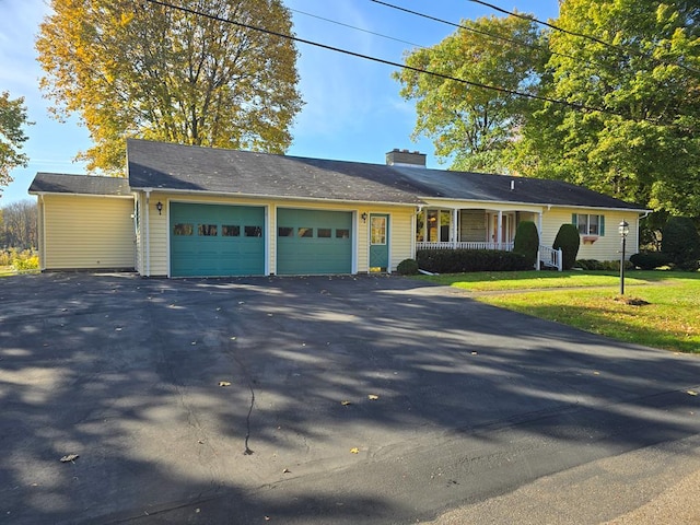 single story home with a porch, a garage, and a front yard