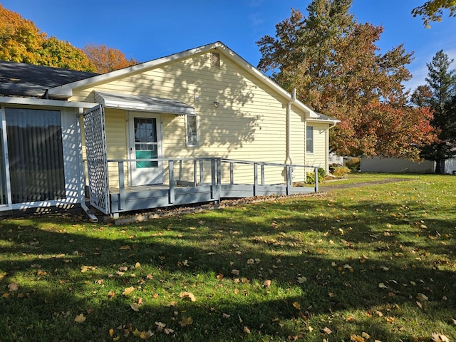 view of side of property with a lawn and a wooden deck