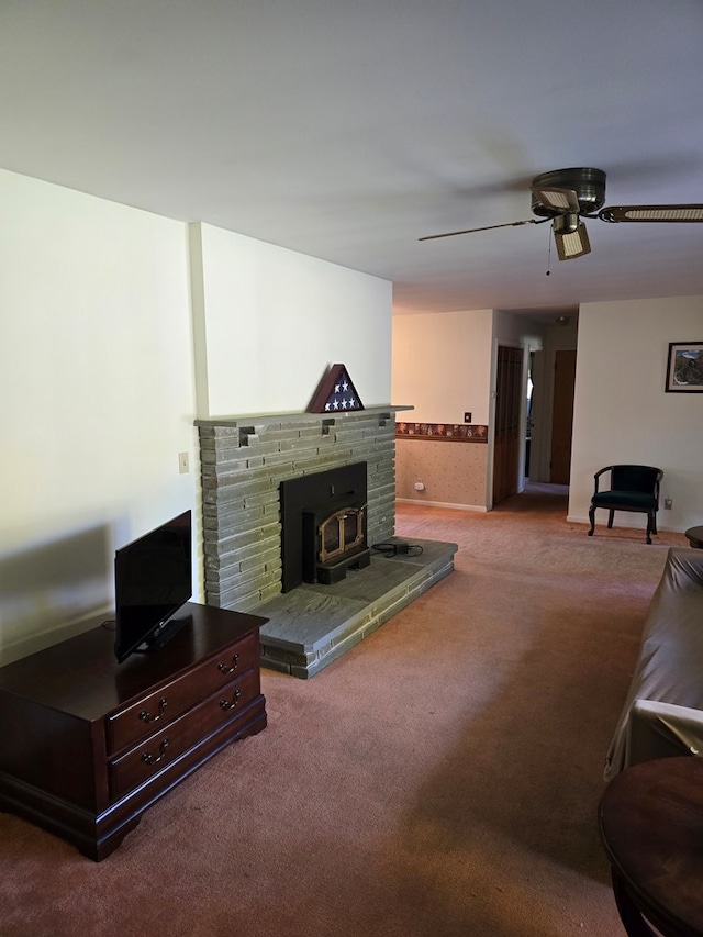 carpeted living room featuring a wood stove and ceiling fan