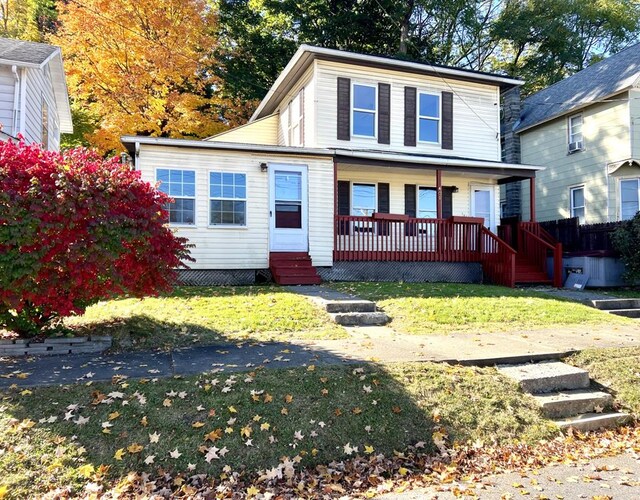 view of front of home with covered porch and a front lawn