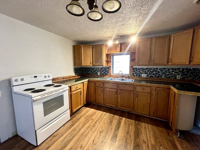 kitchen with sink, decorative backsplash, electric range, a textured ceiling, and light hardwood / wood-style flooring