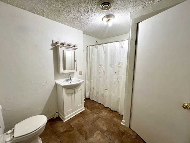 bathroom featuring walk in shower, vanity, toilet, and a textured ceiling