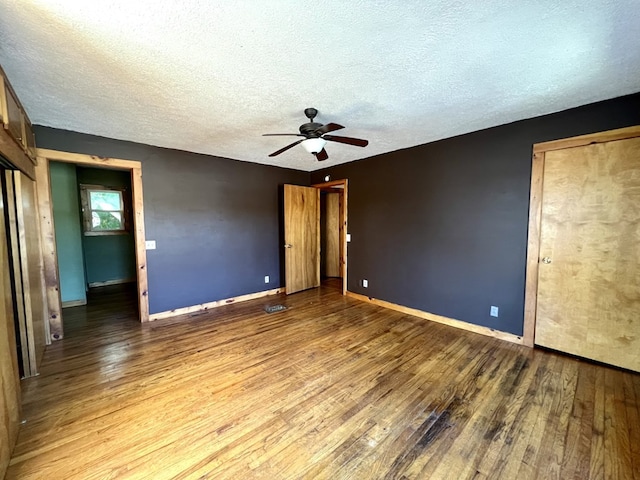 unfurnished bedroom with ceiling fan, wood-type flooring, and a textured ceiling