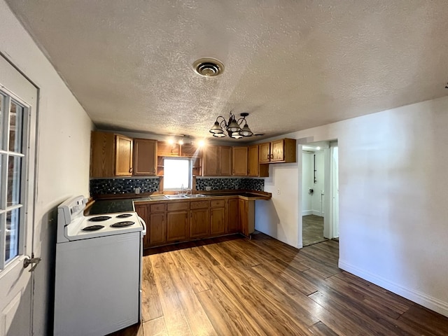 kitchen with tasteful backsplash, white electric range, sink, and wood-type flooring