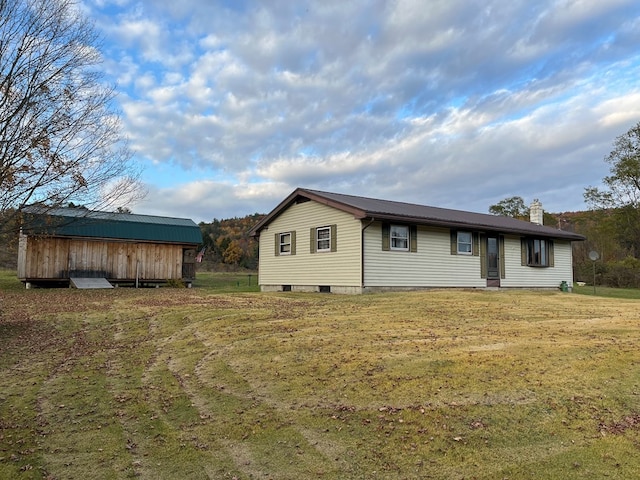 exterior space featuring a front lawn and an outbuilding