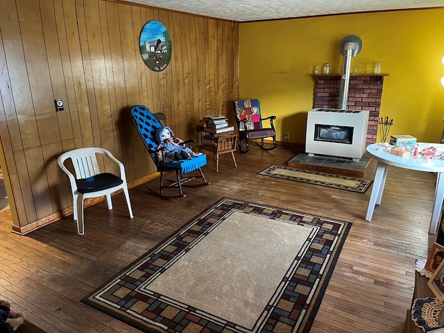 living area featuring wood-type flooring, a textured ceiling, and wooden walls