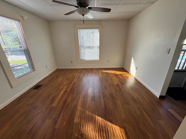 empty room with ceiling fan and dark hardwood / wood-style flooring