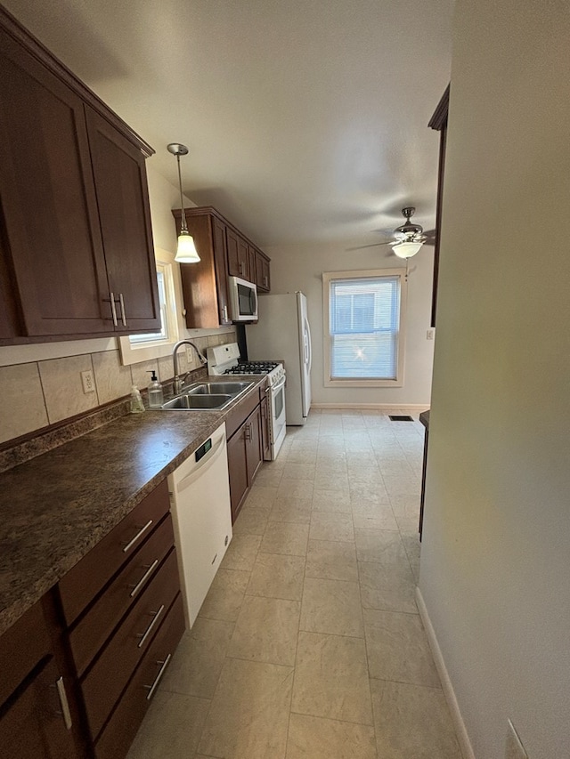 kitchen with tasteful backsplash, sink, hanging light fixtures, ceiling fan, and white appliances