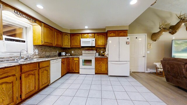 kitchen featuring decorative backsplash, sink, light tile patterned floors, and white appliances