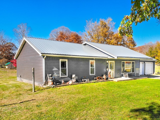 back of property with a yard and a garage