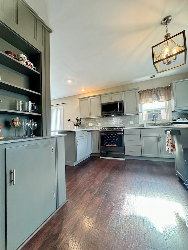 kitchen featuring dark wood-type flooring, stainless steel range oven, gray cabinetry, hanging light fixtures, and decorative backsplash