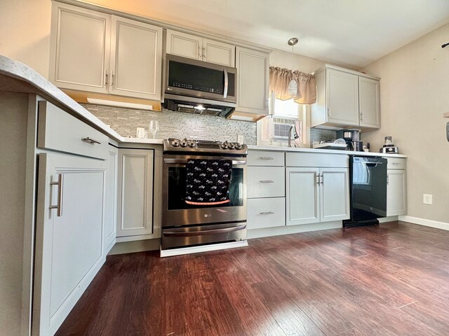 kitchen featuring dark wood-type flooring, pendant lighting, appliances with stainless steel finishes, and decorative backsplash