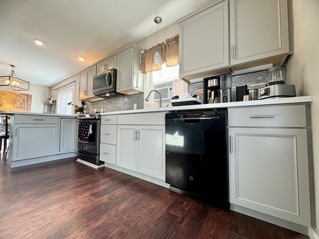 kitchen with a wealth of natural light, dark hardwood / wood-style floors, pendant lighting, and dishwasher