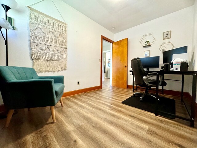 home office with light hardwood / wood-style flooring