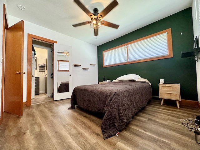 bedroom with ceiling fan, lofted ceiling, multiple windows, and light wood-type flooring