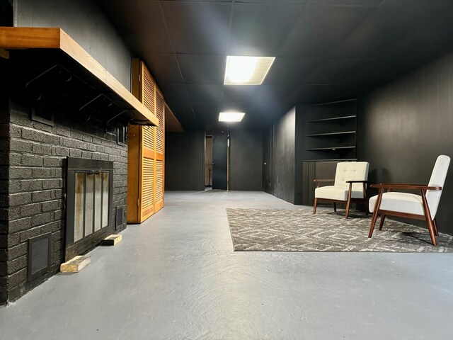 basement featuring built in shelves and a fireplace