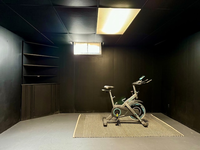 exercise area featuring built in features and wooden walls