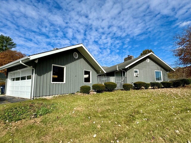 view of side of home featuring a garage and a yard